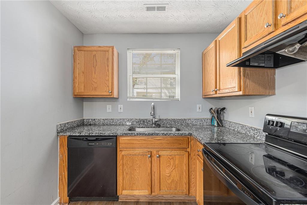 6536 Arbor Gate Drive Southwest, Unit 2 Mableton, GA 30126 - Photo 10 of 27 a kitchen with granite countertop cabinets stainless steel appliances a sink and a window