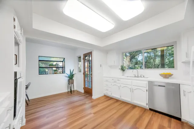 a kitchen with stainless steel appliances a stove a sink dishwasher and a refrigerator with wooden floor