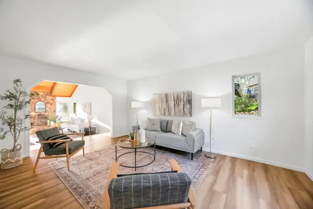 a living room with furniture a rug and a large window