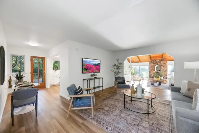 a living room with furniture a dining table and paintings on the wall