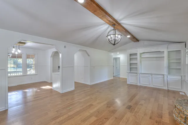 a large kitchen with kitchen island a chandelier stainless steel appliances cabinets and a counter top space