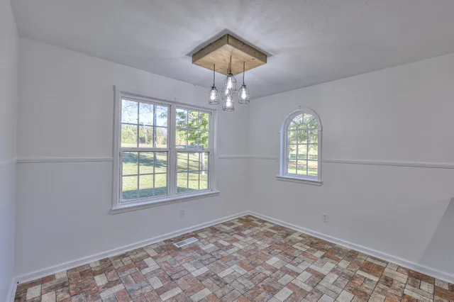 a view of empty room with window and ceiling fan
