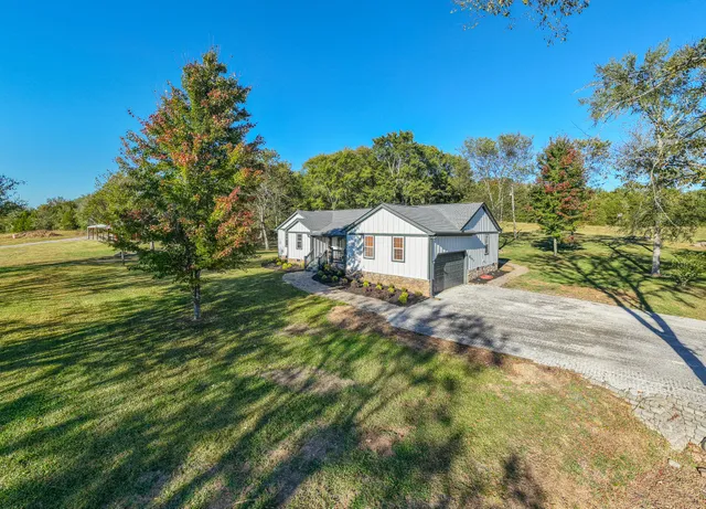 a view of a house with a yard and a garage