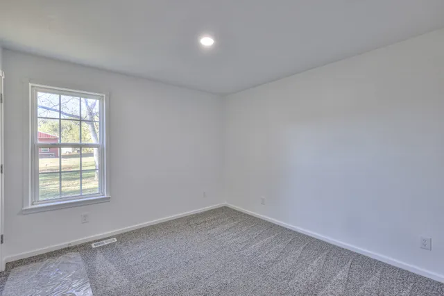 a view of a house with backyard and trees