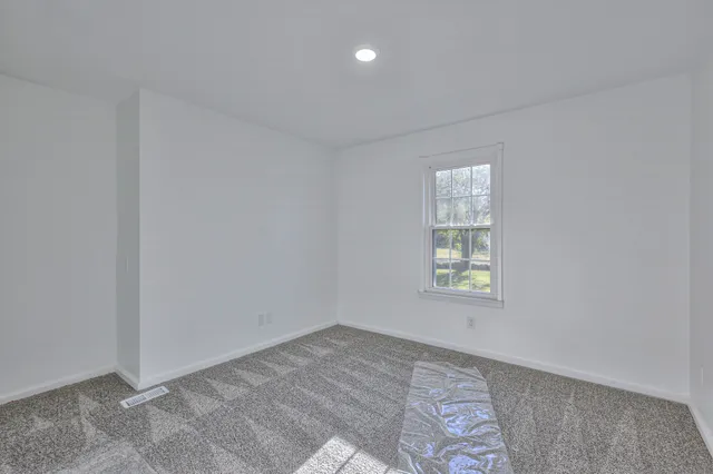 a view of a house with a yard and large tree