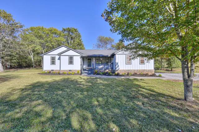 a view of a livingroom with a fireplace a chandelier and wooden floor