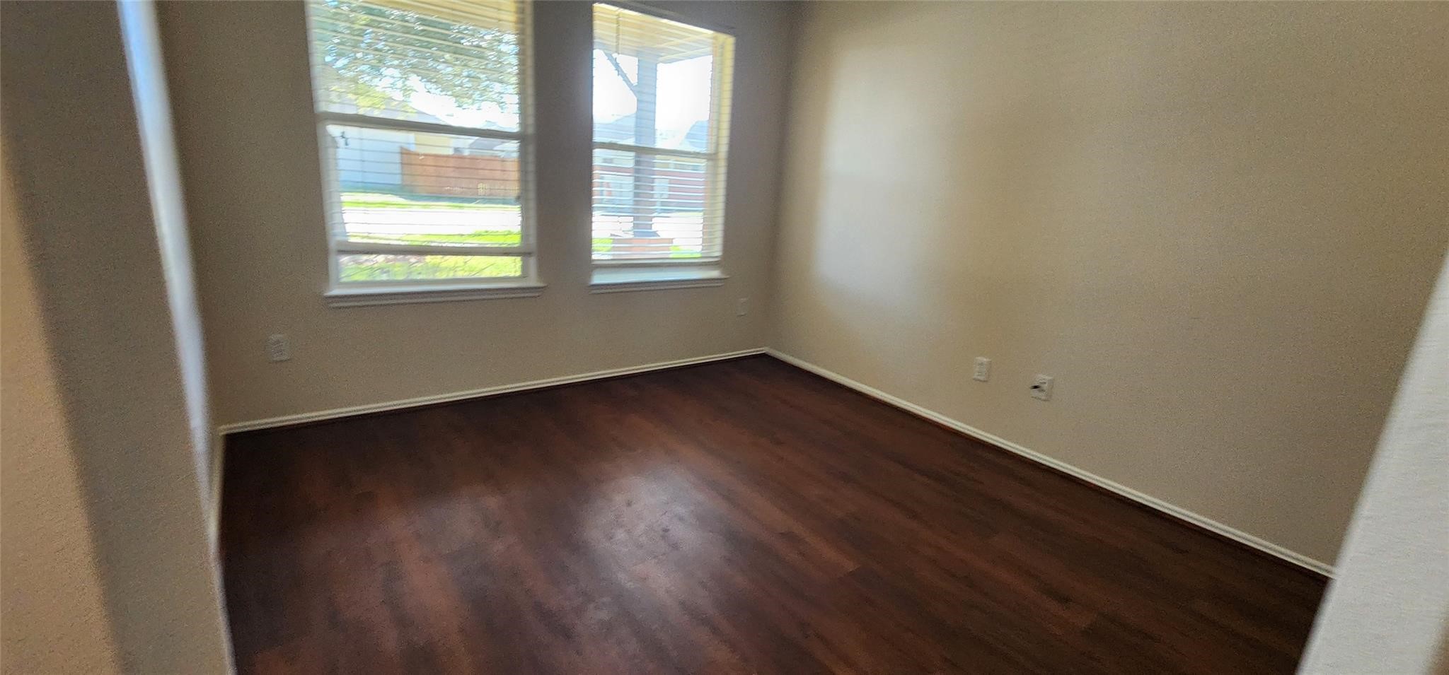 315 Sunset Colony Drive Rosharon, TX 77583 - Photo 2 of 20 an empty room with wooden floor and windows
