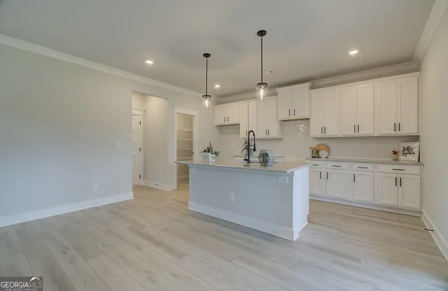 a open kitchen with white cabinets white stainless steel appliances and wooden floor