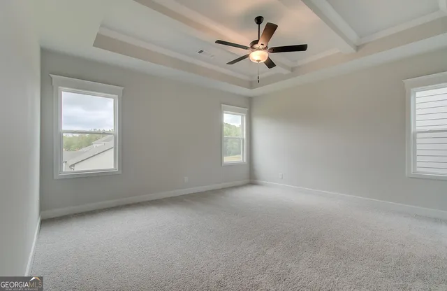 an empty room with windows and fan