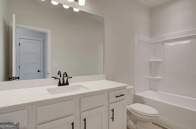 a bathroom with a sink toilet vanity and tub