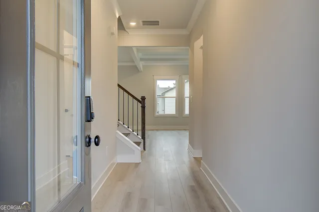 a view of a hallway with wooden floor and staircase