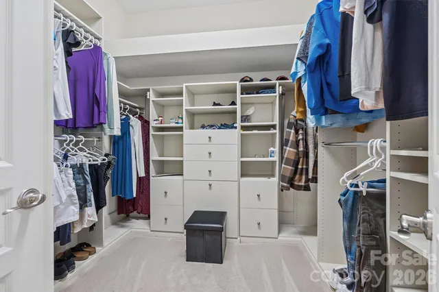 a view of walk in closet with clothes and shoes