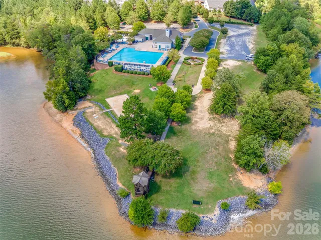 an aerial view of a house with a yard and lake view
