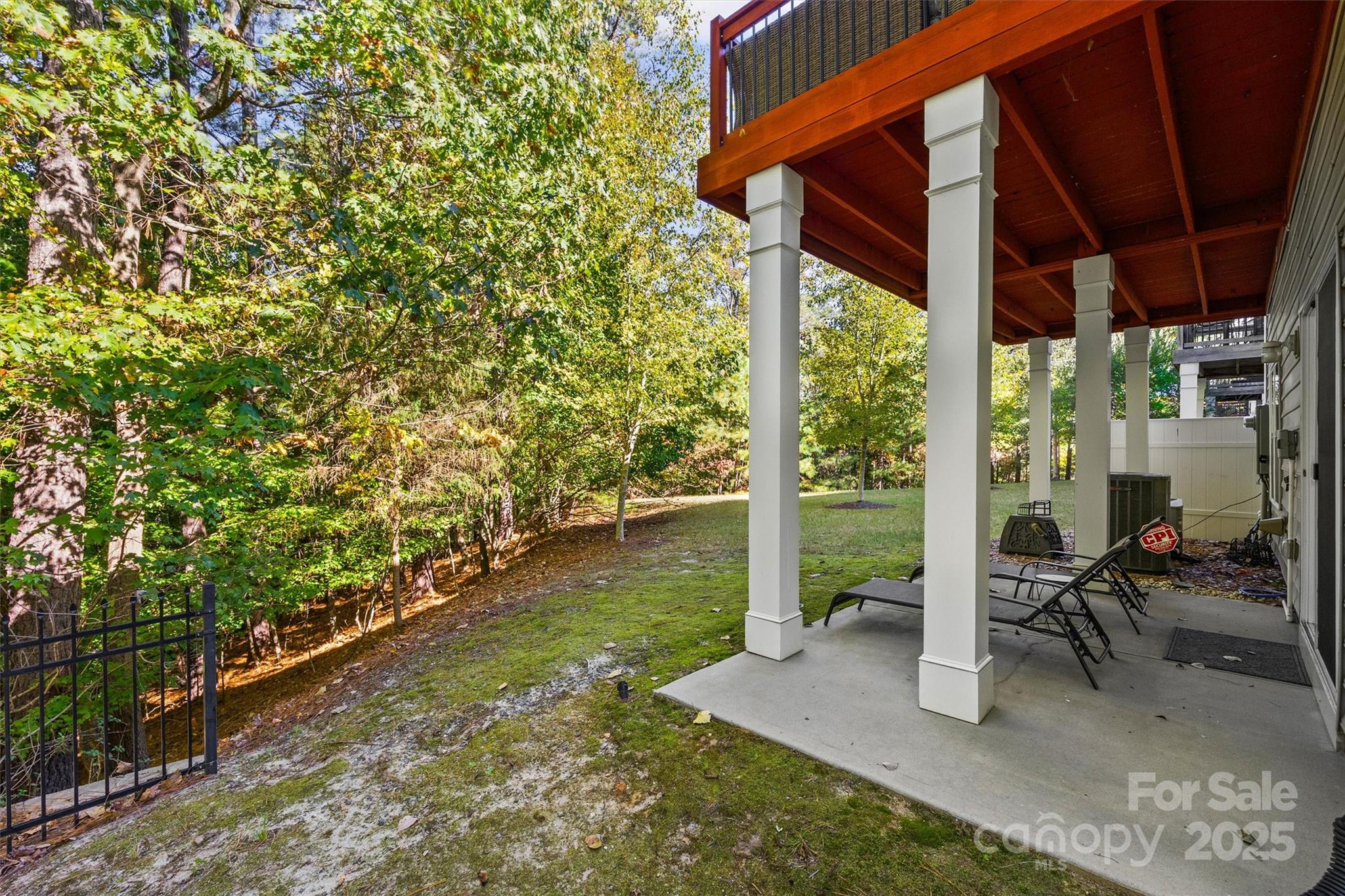 2090 Calloway Pines Drive Tega Cay, SC 29708 - Photo 37 of 38 a view of a patio with table and chairs potted plants with floor to ceiling window and wooden fence