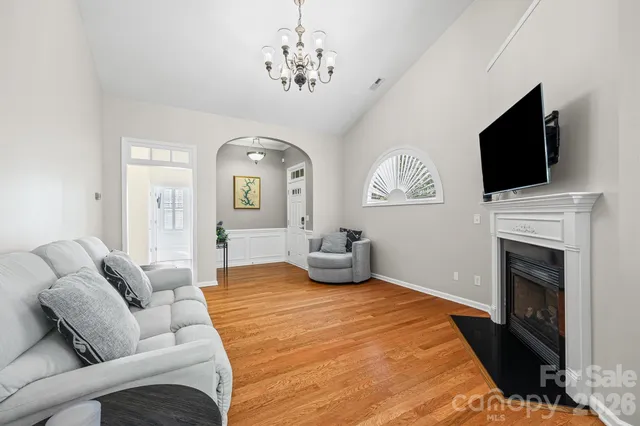 a bedroom with a bed a flat screen tv and a fireplace