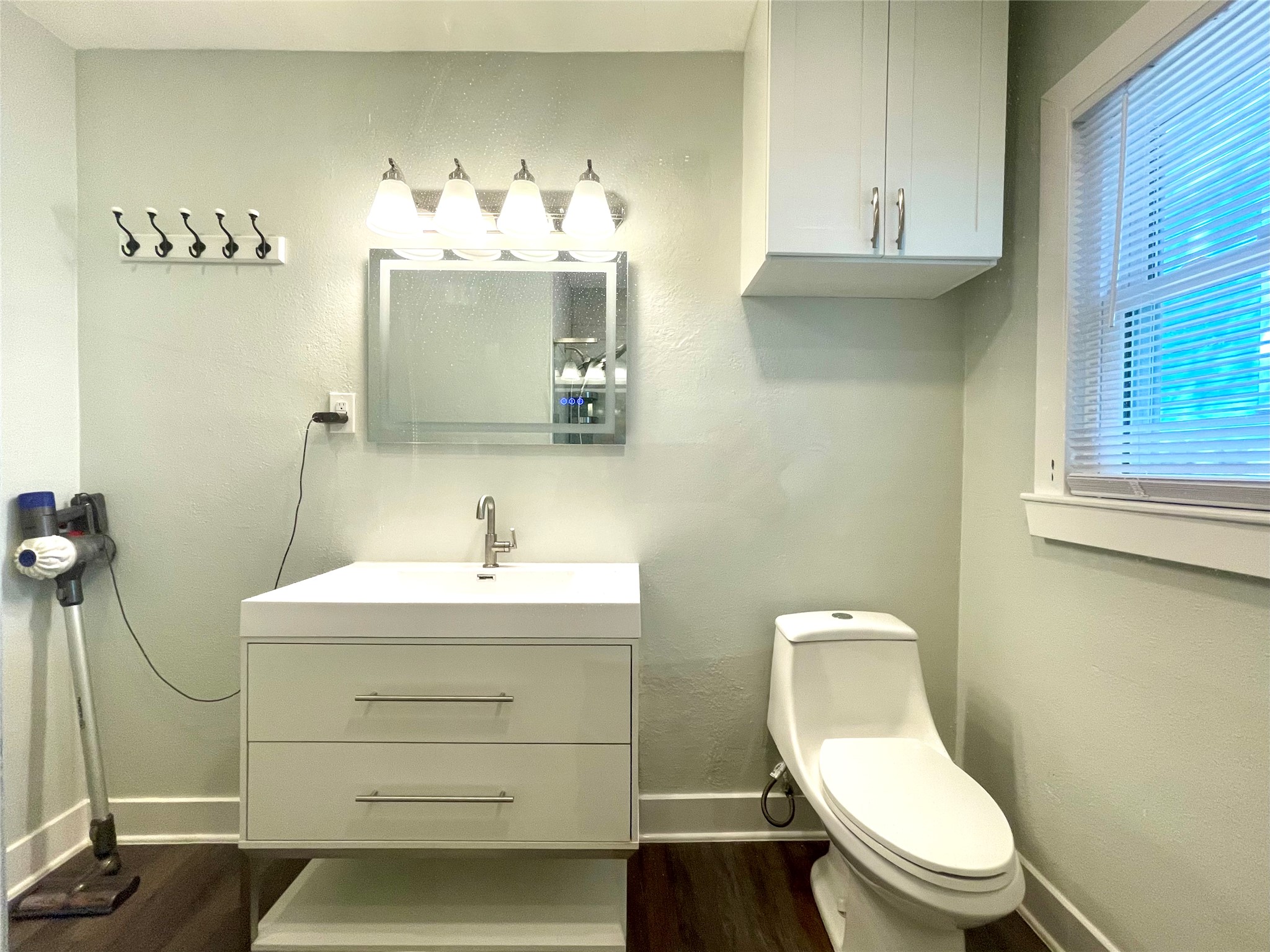 807 East Riverside Drive, Unit B Austin, TX 78704 - Photo 18 of 28 A well-appointed lavatory boasts a contemporary vanity and dark wood flooring, offering convenience.