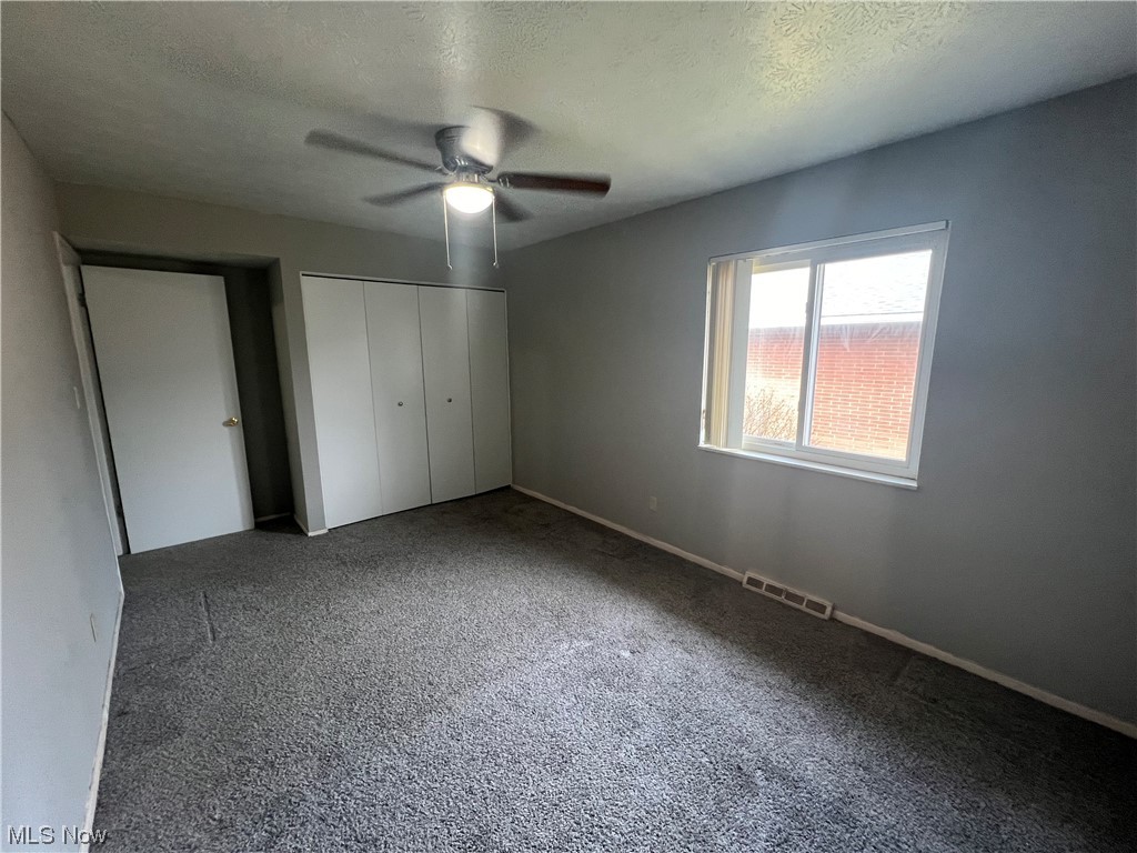 5651 Broadview Road, Unit C 07 Cleveland, OH 44134 - Photo 10 of 15 Unfurnished bedroom with carpet, a closet, a textured ceiling, and ceiling fan