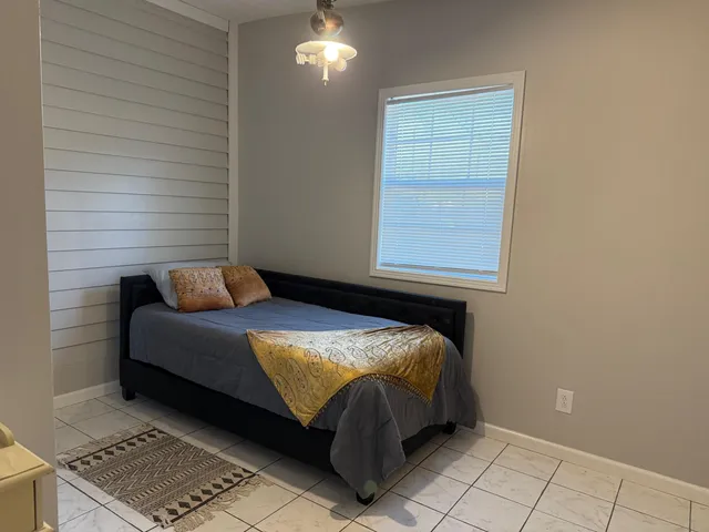 a bed sitting in a bedroom next to a window