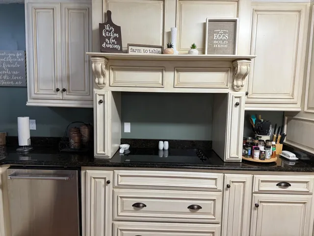 a kitchen with granite countertop white cabinets and black appliances