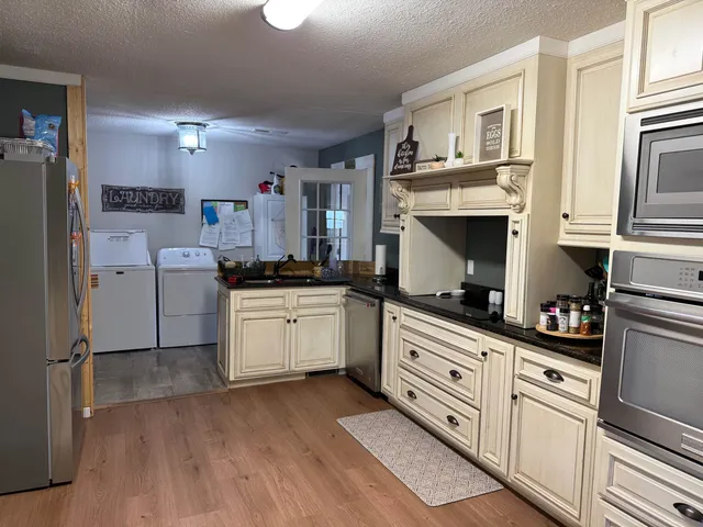 a kitchen with white cabinets and appliances