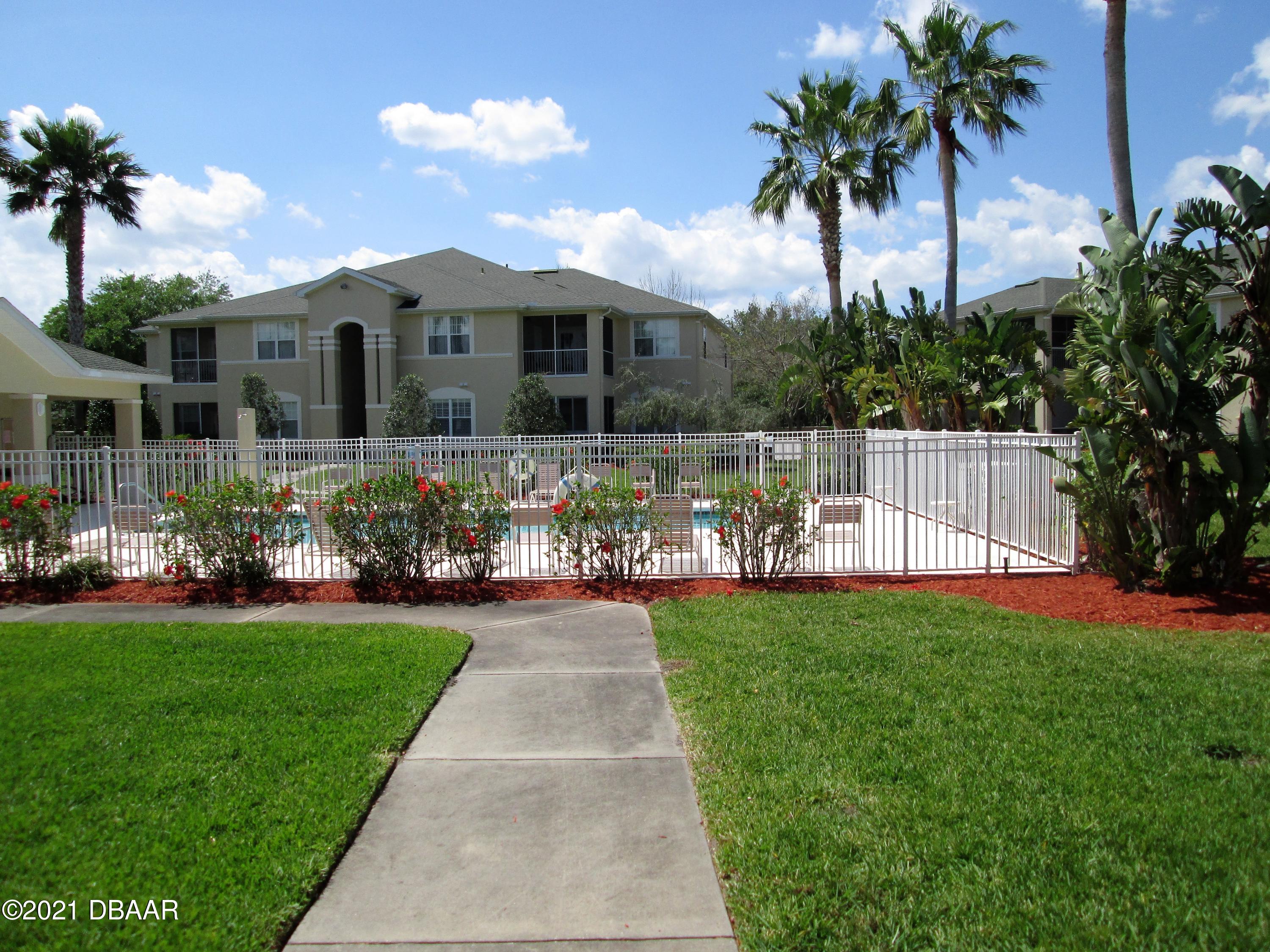 830 Airport Road, Unit 711 Port Orange, FL 32128 - Photo 12 of 47 a front view of a house with a garden and yard