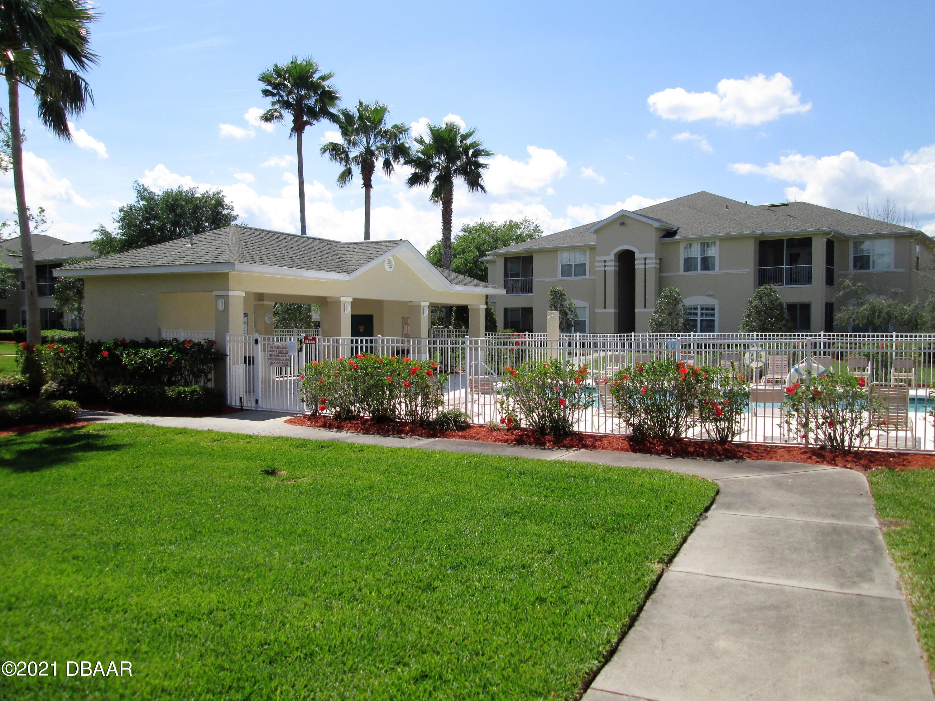 830 Airport Road, Unit 711 Port Orange, FL 32128 - Photo 13 of 47 a front view of a house with a garden and plants