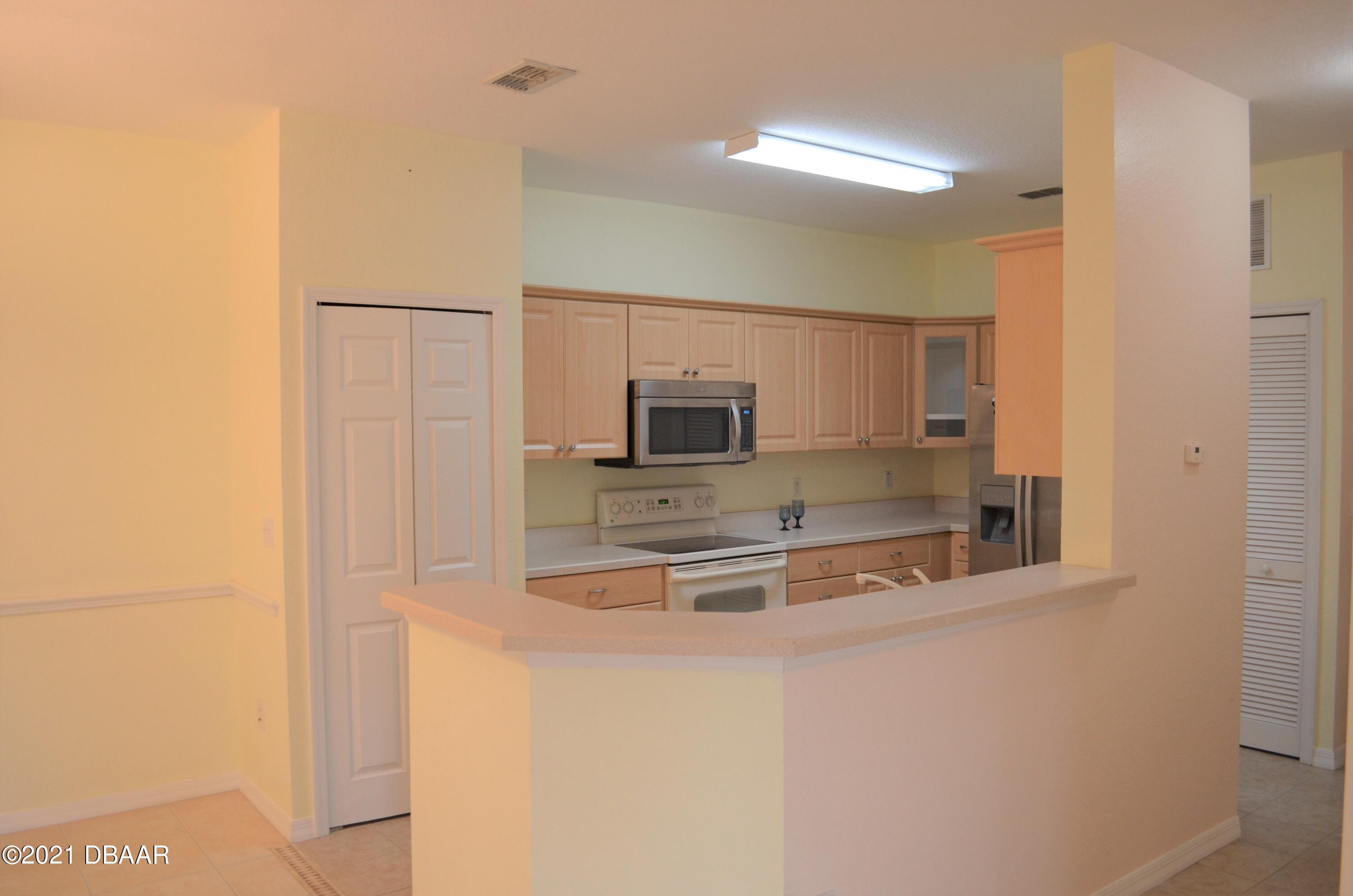 830 Airport Road, Unit 711 Port Orange, FL 32128 - Photo 18 of 47 a kitchen with stainless steel appliances granite countertop a sink and a refrigerator