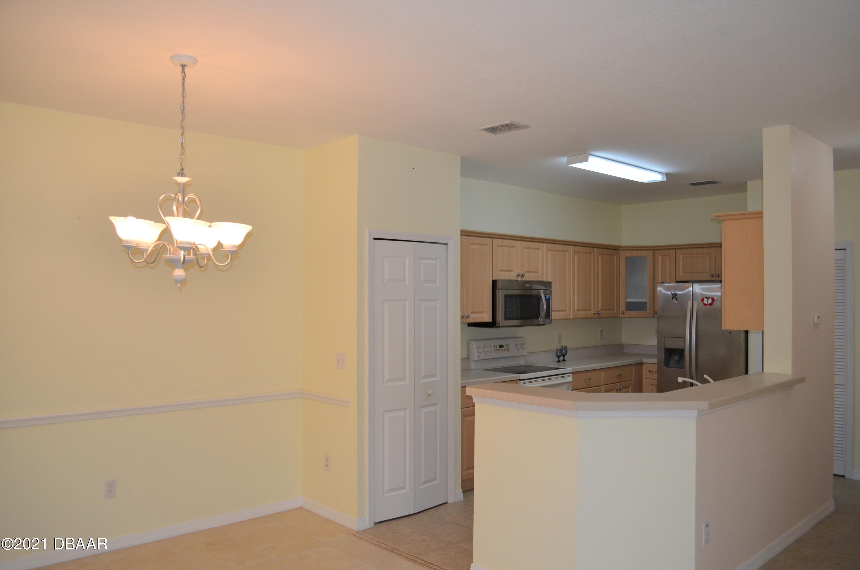 830 Airport Road, Unit 711 Port Orange, FL 32128 - Photo 19 of 47 a kitchen with kitchen island a counter top space appliances and cabinets
