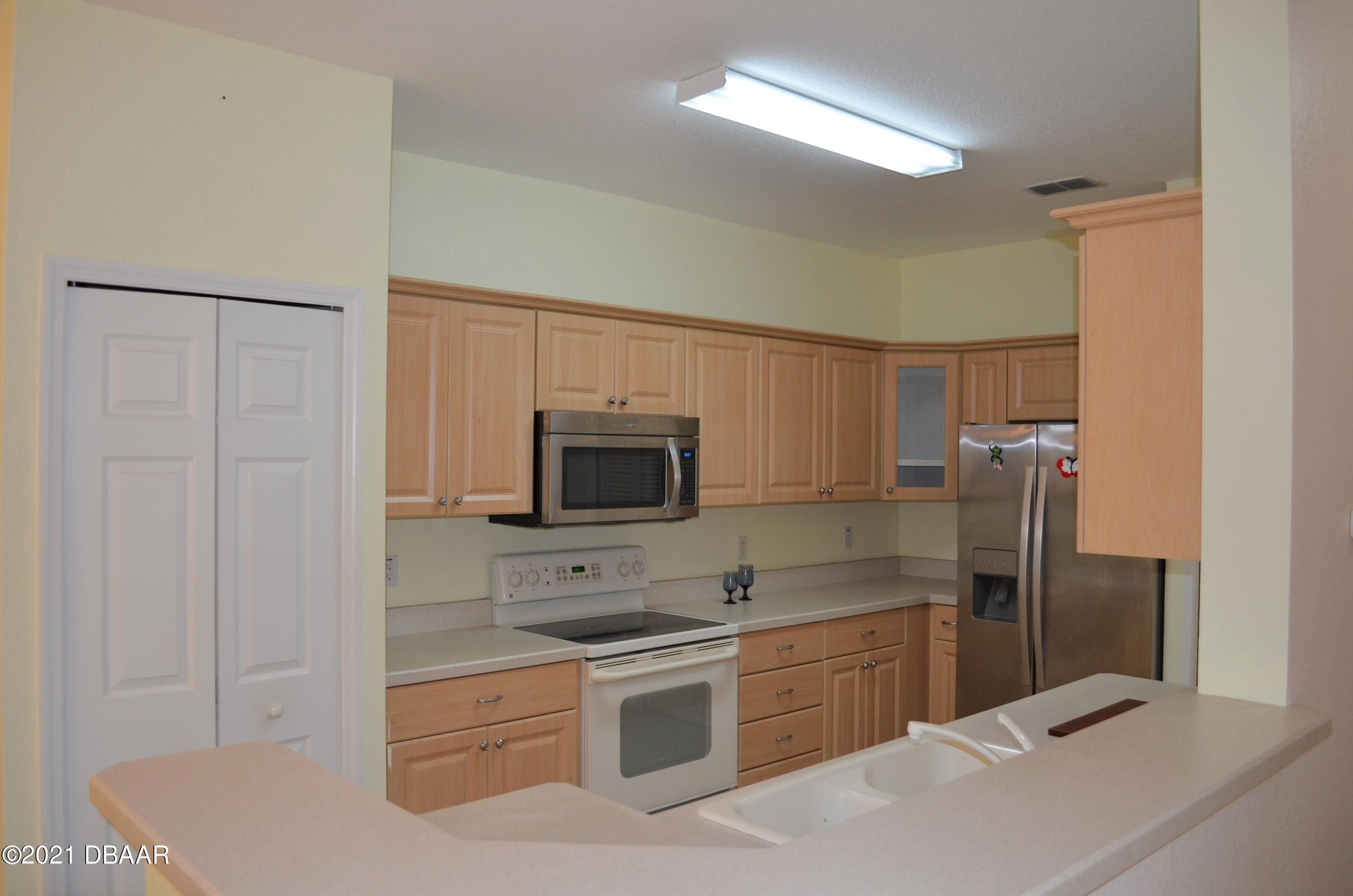 830 Airport Road, Unit 711 Port Orange, FL 32128 - Photo 2 of 47 a kitchen with a refrigerator stove and sink
