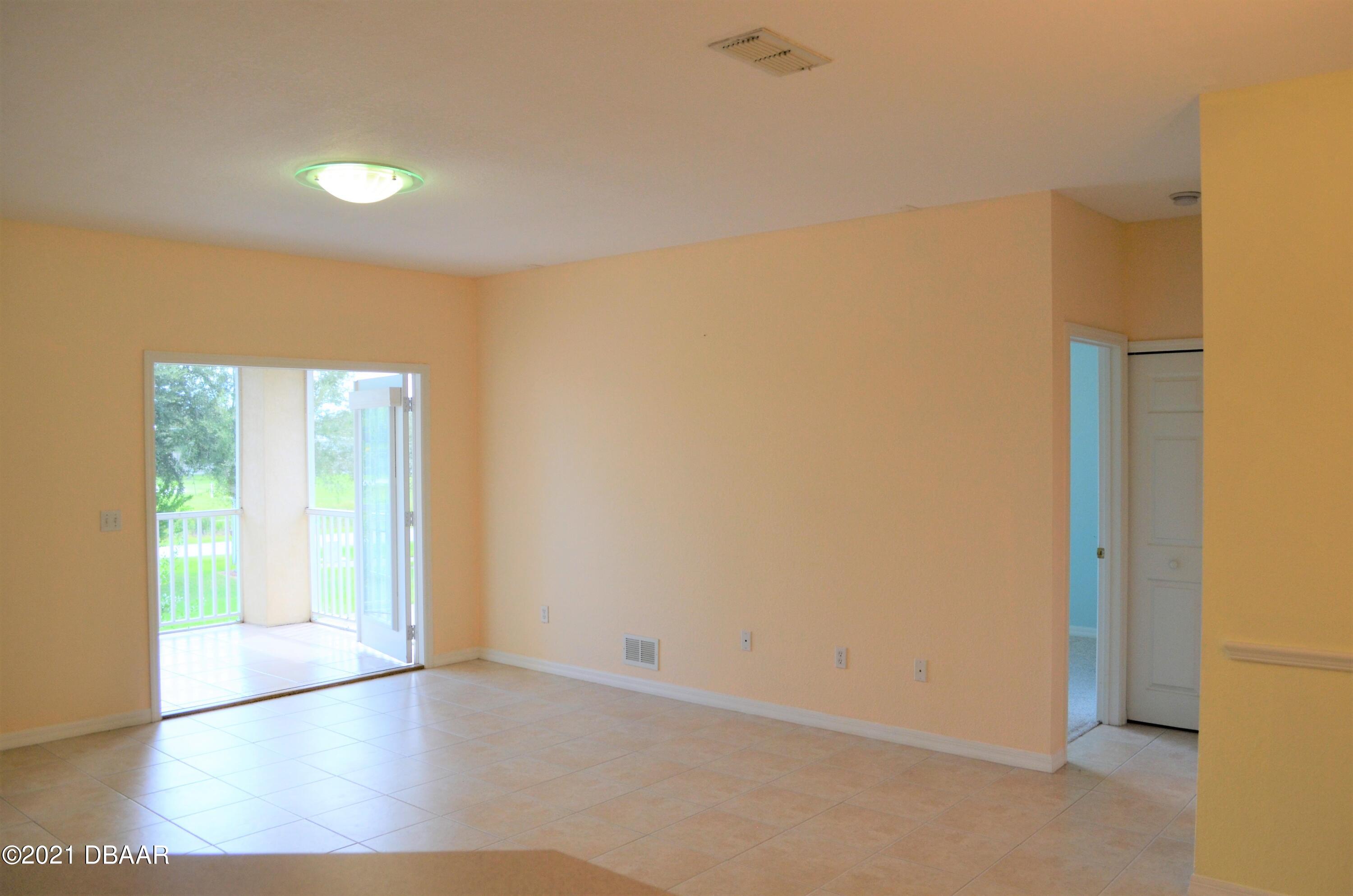830 Airport Road, Unit 711 Port Orange, FL 32128 - Photo 22 of 47 a view of an empty room with wooden floor and a window
