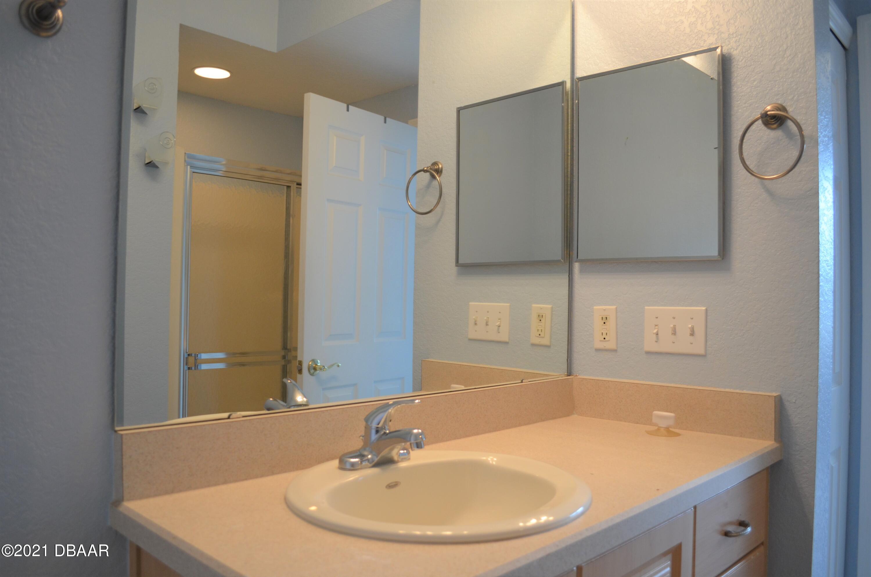830 Airport Road, Unit 711 Port Orange, FL 32128 - Photo 34 of 47 a bathroom with a sink a mirror and a shower
