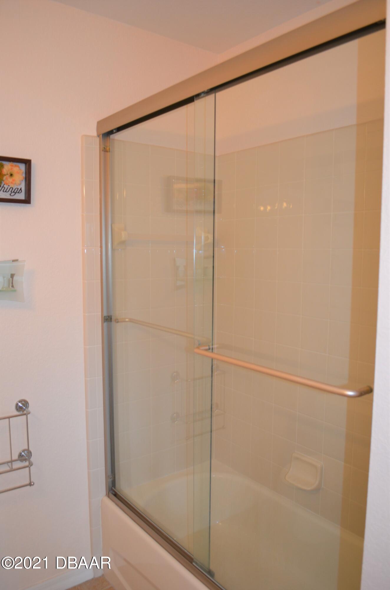 830 Airport Road, Unit 711 Port Orange, FL 32128 - Photo 41 of 47 a bathroom with a glass shower door