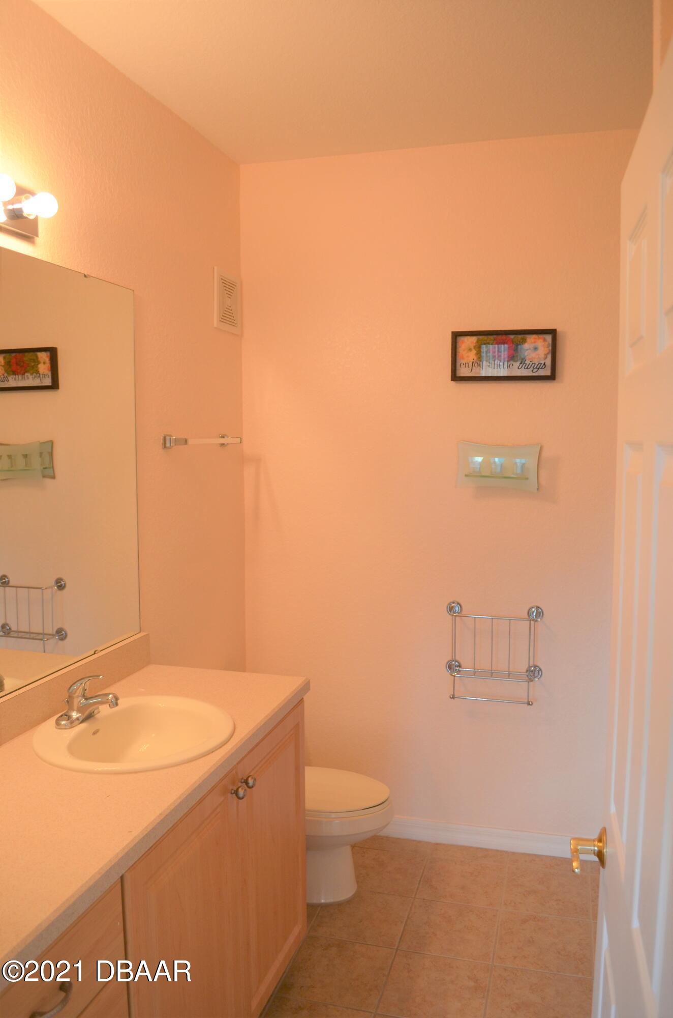 830 Airport Road, Unit 711 Port Orange, FL 32128 - Photo 9 of 47 a bathroom with a sink a toilet and mirror