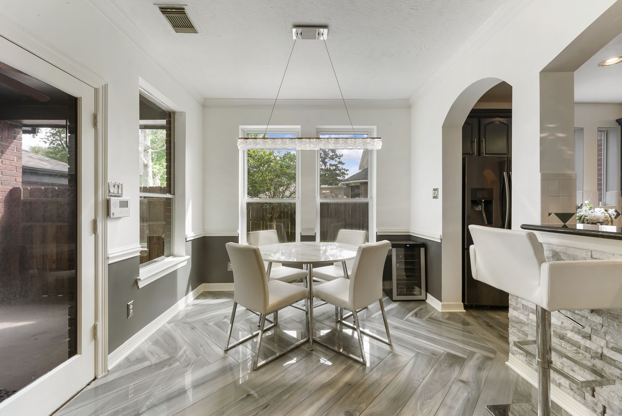 12907 Ryaneagles Circle Houston, TX 77044 - Photo 13 of 48 a dining room with wooden floor a chandelier a glass table and chairs