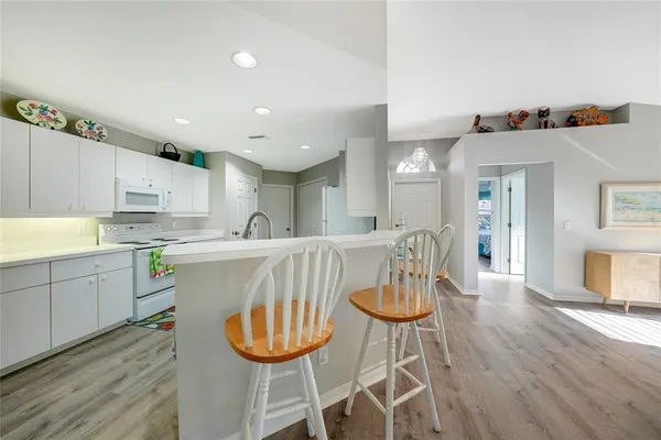 a kitchen with stainless steel appliances a dining table chairs and wooden floor