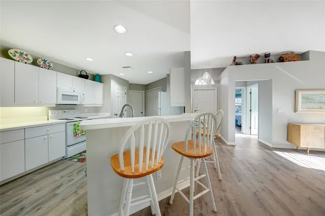 a kitchen with stainless steel appliances a dining table chairs and wooden floor