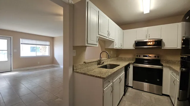 a kitchen with stainless steel appliances granite countertop a sink stove and microwave