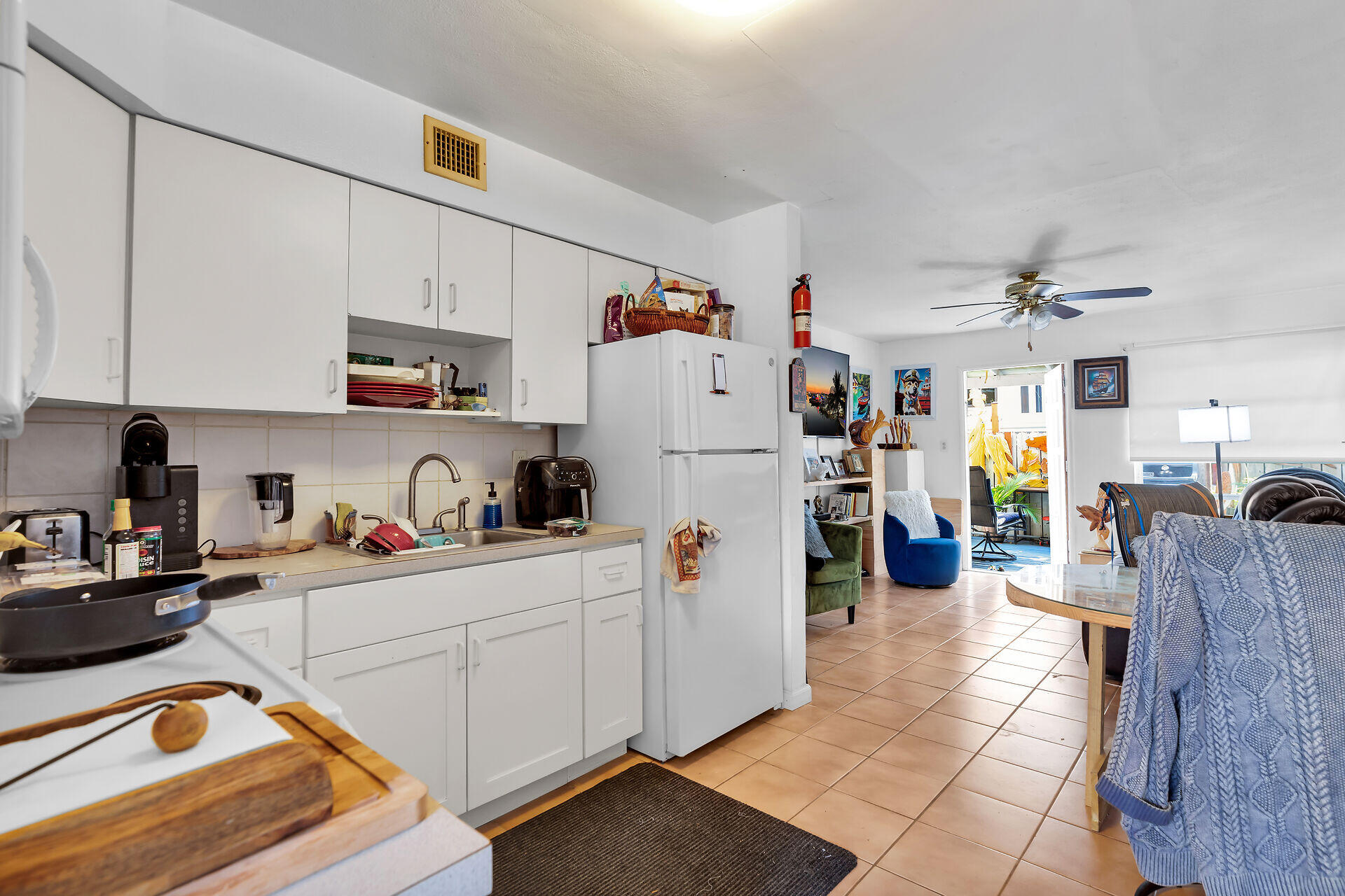 1614 Dennis Street Key West, FL 33040 - Photo 36 of 59 a kitchen with a refrigerator a stove top oven a sink dishwasher and white cabinets next to a window