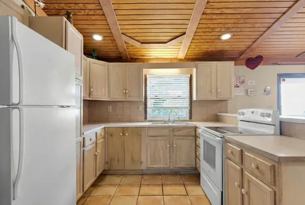a kitchen with a sink a refrigerator and window