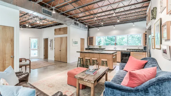 a living room with furniture kitchen view and a large window