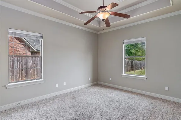 a view of an empty room with a window and a ceiling fan
