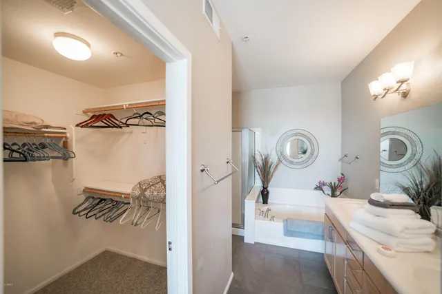 a en suite bathroom with a granite countertop sink and a mirror