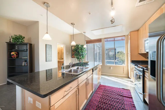 a kitchen with granite countertop a sink a counter space appliances and cabinets