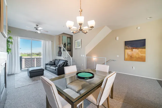 a view of a dining room with furniture a chandelier and wooden floor