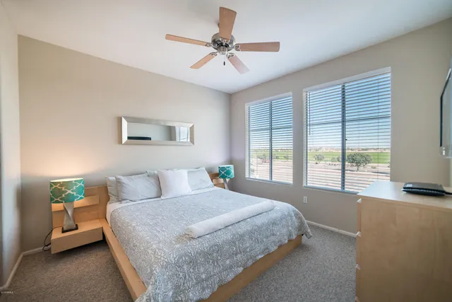 a bedroom with a bed and a large window