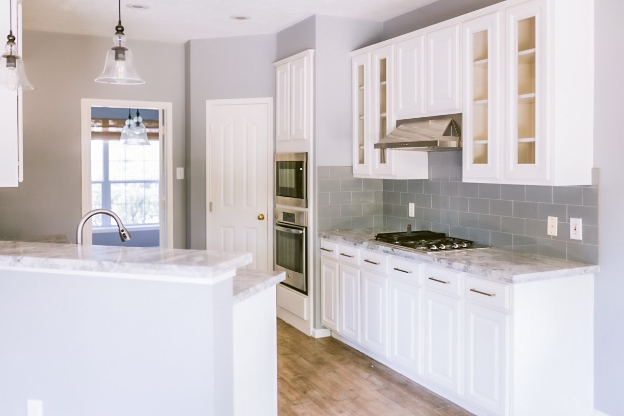 22402 Rue Canyon Court Katy, TX 77450 - Photo 5 of 18 The sleek countertops stretch across an expansive breakfast bar that overlooks a charming, window-lined breakfast nook, making it the perfect spot for morning coffee or casual entertaining.