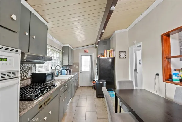 a kitchen with stainless steel appliances granite countertop a refrigerator a stove and a sink with cabinets