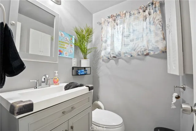 a bathroom with a sink a toilet and a mirror