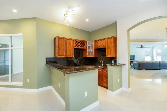 a kitchen with stainless steel appliances granite countertop a refrigerator a stove top oven a sink and dishwasher