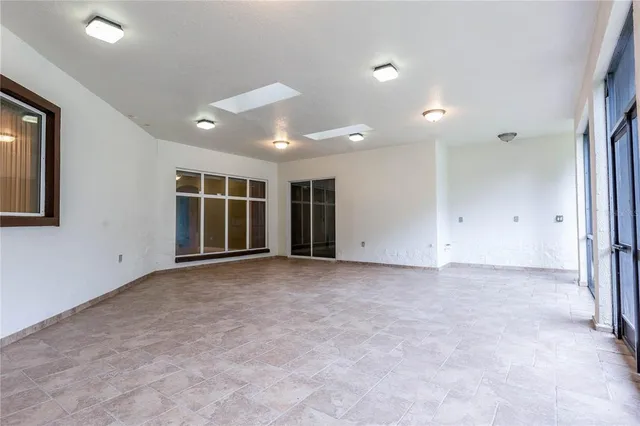 a view of an empty room with a floor to ceiling window and an empty room